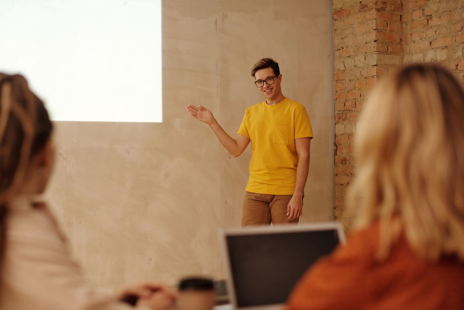 A person presenting to a small group with a laptop open