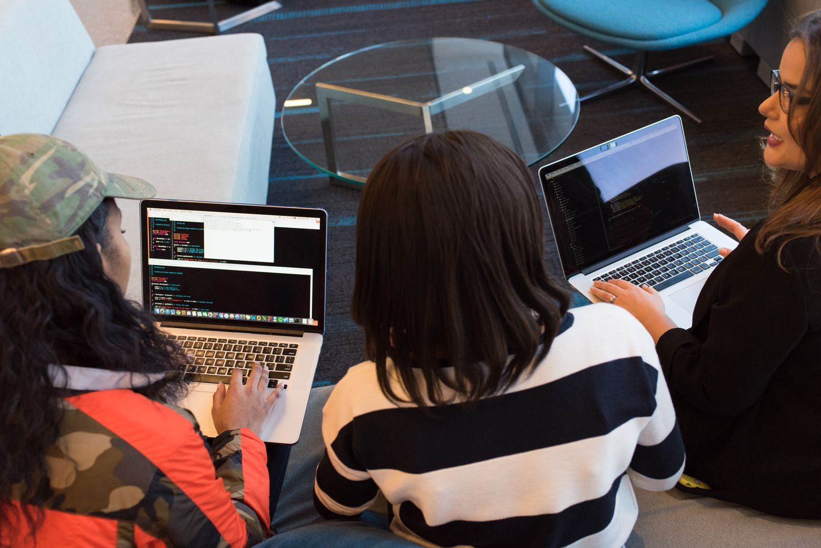 Three people working on laptops side by side
