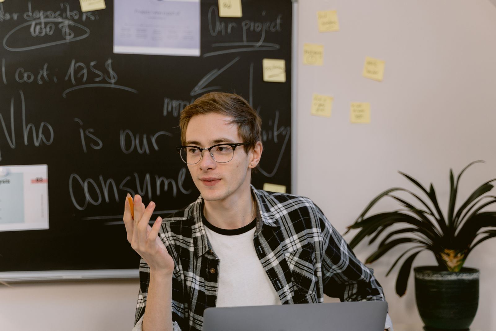 A student talking through ideas in front of a chalkboard