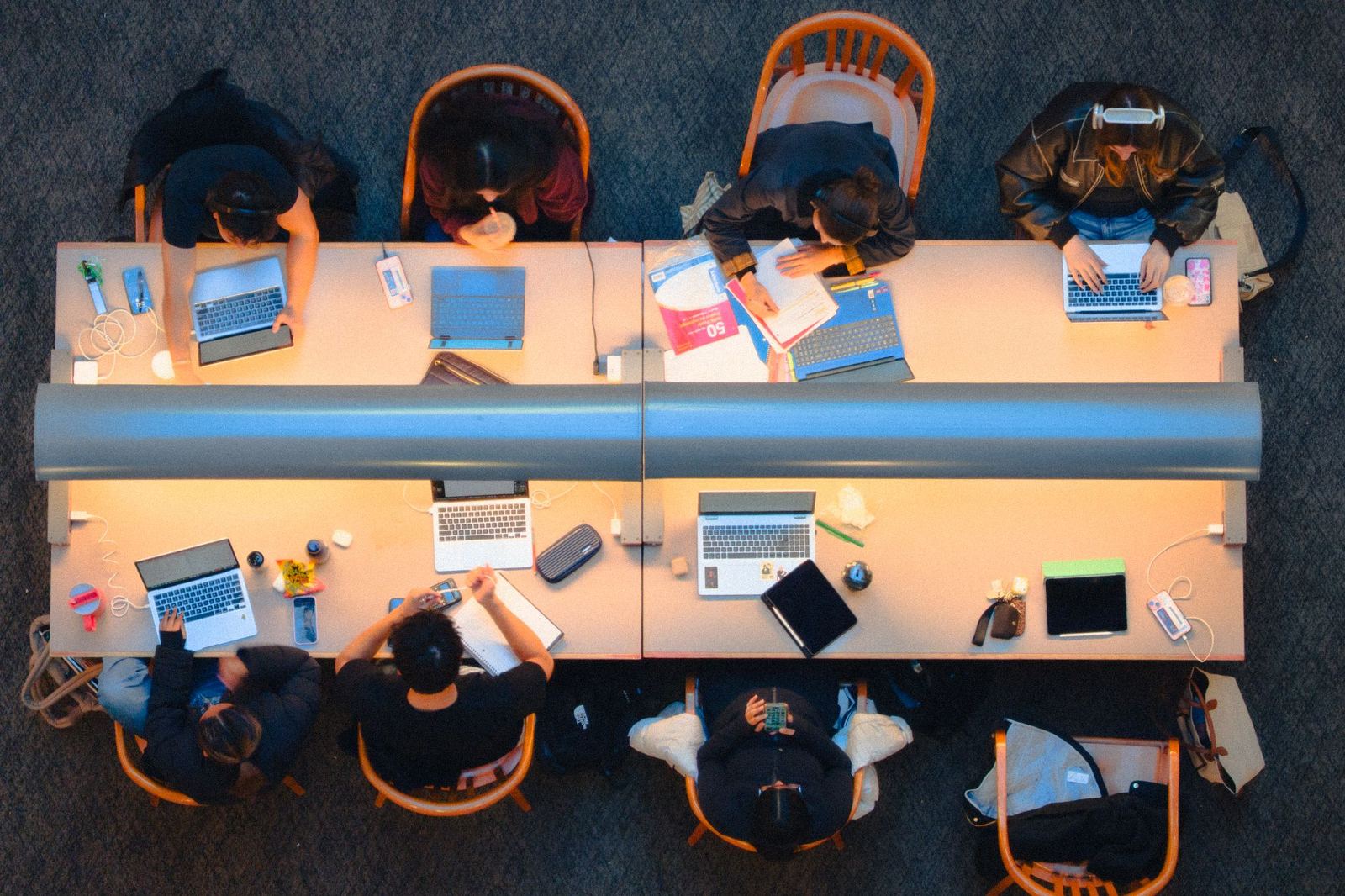 Students working on laptops in a library, seen from above